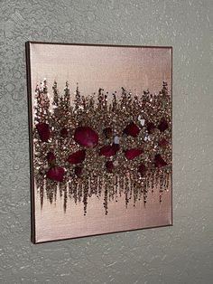 a painting hanging on the wall with beads and crystals in it's center piece