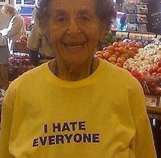 an older woman wearing a yellow shirt that says i hate everyone