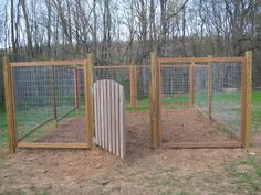 an outdoor chicken coop in the middle of some grass and dirt with fencing around it