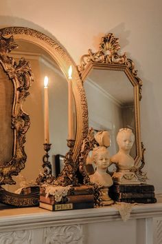 there is a mirror on the mantle with candles in front of it and a busturine next to it