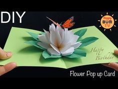 someone is holding an open card with a flower on it and the words happy birthday written in