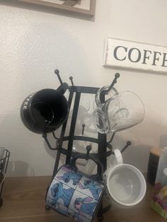 there is a coffee cup holder on the table with cups and mugs in it