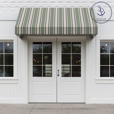 two white doors with red and orange awnings