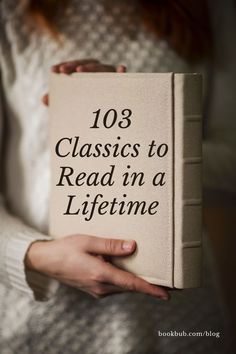 a person holding a book with the title 103 classics to read in a life time