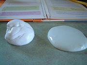 two white spoons sitting on top of a table next to a binder and book