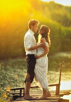 a man and woman are standing on a dock