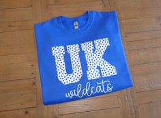 "University of Kentucky ~ Go Wildcats! Make sure you have your game day apparel with this custom UK sweatshirt! This is a Gildan unisex fit sweatshirt shown on Royal Blue. The letters are sewn on with an applique stitch and personalized with Wildcats in white vinyl. All vinyl is cut to order, heat pressed on with an industrial press for a smooth finish! You can choose your sweatshirt color and size in the drop down boxes. In \"notes to seller\" please leave if you wish for another color for personalization or no personalization. I can also do Wildcats in royal blue. If you wish to customize the wording, or a new design please send a custom request message prior to purchasing. Wash and care: Turn inside out, wash regular cycle, no fabric softener. Hang dry. RETURN/EXCHANGE POLICY: There are College Spirit Wear, Cambridge University Sweatshirt, Uk Shirts Kentucky, Kentucky Wildcats Svg, Kentucky Shirts, Kentucky Sweatshirt, Kentucky Wildcats Shirt, Kentucky Wildcats Football, Applique Sweatshirt