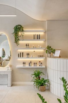 the interior of a salon with plants and bottles on shelves