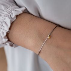 "Our Dainty Ball Bracelets are made with a strong nylon cord and a beautiful solid 18k gold ball charm.  A minimalistic design with a lasting effect.  These bracelets are great for gift giving as Friendship Bracelets or a minimalist everyday jewelry piece. Each bracelet is mounted on our gift cards marked 18k gold and packaged in our Vivien Frank gift box. Details: ✦ 18k solid gold ball charm ✦ charm approx 5mm ✦ Adjustable Nylon Cord ✦ water proof First image is of ombre - tones of grey If you Adjustable Minimalist Gold Bracelet For Gift, Adjustable White Gold Bracelet For Everyday, Elegant Adjustable Friendship Bracelets As Gift, Elegant Adjustable Cord Friendship Bracelets As Gifts, Modern Adjustable White Gold Bracelet, Elegant Bracelets With Adjustable Cord For Gifts, Minimalist Yellow Gold Braided Bracelets As Gift, Elegant Adjustable Cord Bracelets As Gift, Elegant Adjustable Cord Bracelet For Gifts