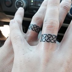 two hands with rings on their fingers in front of a steering wheel