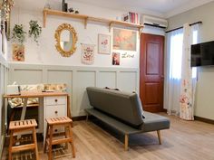 a living room filled with furniture and a flat screen tv mounted to the side of a wall