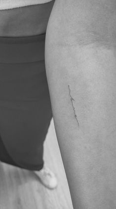 a woman's thigh with a small tattoo on it