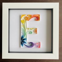 the letter e is made out of paper and painted with colorful swirls on it