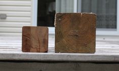 two blocks of wood sitting on top of a wooden table next to a building door