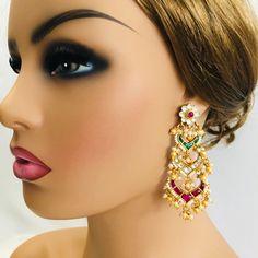 Beautiful and Unique Style Affordable Luxury traditional Bollywood Chandbali earrings with Kundan stones and Colored ruby semi precious Stones. 22k gold plated jewelry Length: Approx. 3 Inches Click here to see the complete collection of Kundan and Polki Statement Earrings at AryaFashions: https://www.etsy.com/shop/AryaFashions?section_id=25872820 Follow us on social media for new and latest designs: Facebook: www.facebook.com/shoparyafashions Pinterest: www.pinterest.com/aryafashions Instagram: Kundan Chandelier Earrings With Stone Work For Wedding, Party Kundan Jhumkas In Temple Jewelry Style, Kundan Temple Jewelry Jhumkas For Party, Temple Jewelry Kundan Jhumkas For Party, Temple Style Kundan Jhumkas For Party, Kundan Jhumkas For Party, Temple Jewelry Style, Wedding Kundan Chandelier Earrings With Stone Work, Kundan Bridal Earrings With Tilla For Festivals, Heavy Kundan Danglers For Wedding