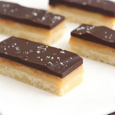 four pieces of dessert sitting on top of a white plate