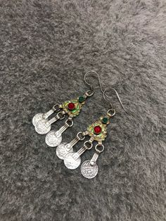 Moroccan Silver EnamelBerber Handmade Earrings with old coins and green-red glass. Enamel Venetian green, yellow. Handmade Moroccan silver crafted earrings. The earrings feature fantastic wirework with mint green, golden yellow. These are light and easy to wear. These earrings are individually hand made and slight variations in workmanship and enamel are normal. Good Condition and 100% handmade item. Length : 8,5cm Width : 2cm Weight : 18,3g Traditional Green Filigree Earrings, Bohemian Meenakari Metal Earrings, Vintage Green Earrings For Festival, Vintage Green Festival Earrings, Festive Silver Enamel Jewelry, Bohemian Enamel Earrings Nickel Free, Bohemian Enamel Earrings Nickel-free, Nickel-free Bohemian Enamel Earrings, Bohemian Green Enamel Earrings