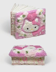 an open book with hello kitty on the cover and pink flowers in the middle, sitting next to a basket