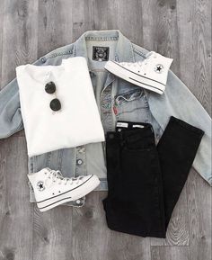 a denim jacket, white shirt and black jeans are laid out on the floor