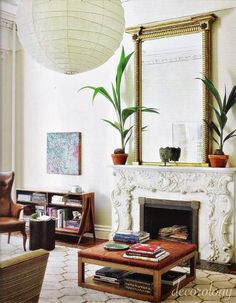 a living room filled with furniture and a fire place in front of a large mirror