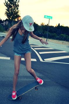 a girl is riding her skateboard down the street