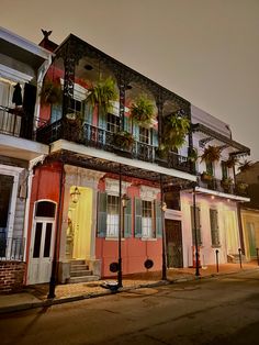 an old building with balconies and palm trees on the balconys is lit up at night