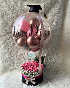 a vase filled with pink flowers and balloons