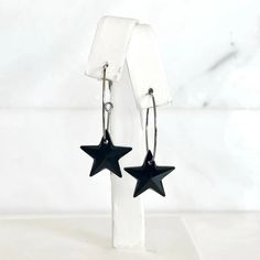 Elevate your jewelry collection with these stunning black Swarovski crystal star earrings. Featuring dazzling black crystal star pendants, each measuring 0.5" in height, these earrings exude sophistication and charm. The star pendants hang gracefully from sleek silver hoops, which add a modern touch to the design. With a total length of 1.5", these versatile earrings are perfect for both casual and formal occasions. Ideal for those who appreciate refined and eye-catching accessories, these black Black Star Charm Earrings, Black Star Charm Jewelry, Nickel-free Black Star Earrings, Black Star-shaped Nickel-free Earrings, Crystal Stars, Ring Sale, Star Pendant, Black Crystals, Silver Hoops