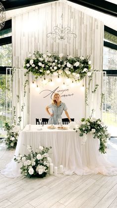 a woman sitting at a table with flowers on it