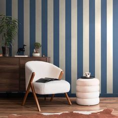 a white chair sitting in front of a blue striped wall