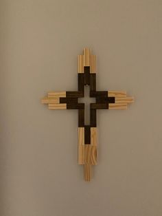 a cross made out of wooden sticks on a wall