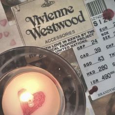 a close up of a candle on a plate with a ticket in front of it