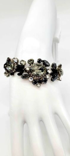 "Black Crystal Bracelet, Statement Bracelet Chunky, Black Rhinestone Bracelet, Cluster Bracelet, Black Stone Bracelet, Sorrelli Bracelet Excellent Condition Measurements: 7.5\"L and 1.25\" Wide Metal: Antiqued Silver Tone Finish: Antiqued, Oxidized, Matte Findings: Fold Over Clasp, snaps right in! Looking for a glamorous statement piece with a hint of edge? This COMPLETELY SWAROVSKI ENCRUSTED dark diamond bracelet from Sorrelli will give you that mysterious sparkle you have been searching for! If you are not familiar with the Sorrelli brand, every single piece they make is HANDCRAFTED, MADE TO LAST A LIFETIME, and has CLASSIC TIMELESS STYLE. They have been in business since the early 80s, this particular vintage piece was made in the 90s. It sparkles like CRAZY and is set in a gorgeous, an Mafia Core, Dragon Video, Black Stone Bracelet, Halo Bracelet, Cluster Bracelet, Cluster Bracelets, Shine Bright Like A Diamond, Diamond Chain, Bracelet Black