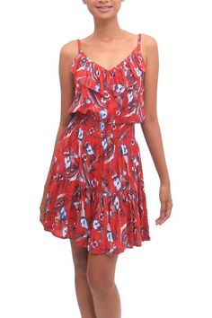 Displaying lovely floral motifs printed over a body of strawberry red this sundress is designed by Bali's Ratu and Devi. Crafted from rayon this lovely dress features a features a ruffle at the neckline and a ruffle at the hem an empire waist and a gathered short skirt.