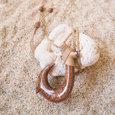 Dive into Hawaiian heritage with our Hilo Koa Wood Fish Hook Necklace, crafted to honor the oceanic legacy of Hilo on the Big Island. This pendant, meticulously carved from rich koa wood, symbolizes strength, prosperity, and respect for the sea. Adorned with hemp wrapping and adjustable koa wood beads, each necklace is a unique homage to traditional Hawaiian craftsmanship. Embrace the spirit of aloha and connect with the natural beauty of the islands with this timeless piece. Wood with hemp wraps Twisted natural hemp cord Hand carved, each unique Adjustable length up to: 28" Pendant: 2.5" x 1.75" Jewelry pouch included (color may differ) In interests of hygiene and for your protection, we cannot accept returns on jewelry. Ring Bearer Dress, Boys Hawaiian Shirt, Girls Sandals Kids, Bridal Flip Flops, Hawaiian Necklace, Shark Tooth Pendant, Fish Hook Necklace, Island Jewelry, Shark Tooth Necklace