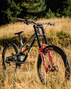 a mountain bike is parked in the tall grass