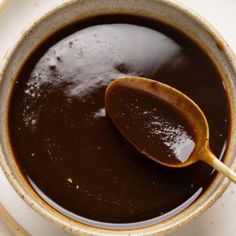 a spoon in a bowl filled with brown liquid