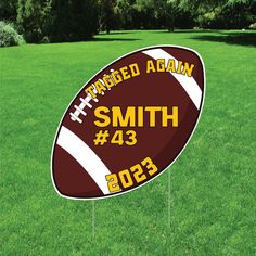 a football shaped yard sign in the grass