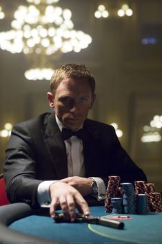 a man in a tuxedo sitting at a table with poker chips