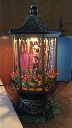 a decorative lantern is lit up on a table