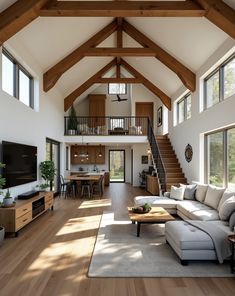 a living room filled with furniture and a large window next to a stair case in front of a flat screen tv