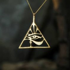 a gold necklace with an egyptian eye in the center