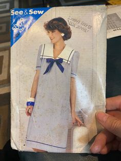 a woman's blue and white dress is being held up to show the pattern