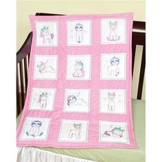 a pink baby quilt with pictures of cats on it