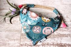 a blue bandana with flowers on it sitting on top of a wooden floor next to a plant