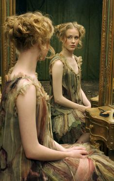 two women sitting in front of a mirror