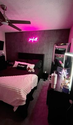 a bed room with a neatly made bed and a neon sign