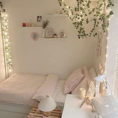 a small bedroom with white walls and lights on the ceiling, along with pink bedding