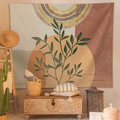 a wall hanging with a plant on it in front of a wooden trunk and basket