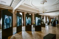 an empty room with several black and white pictures on the walls, in front of a chandelier